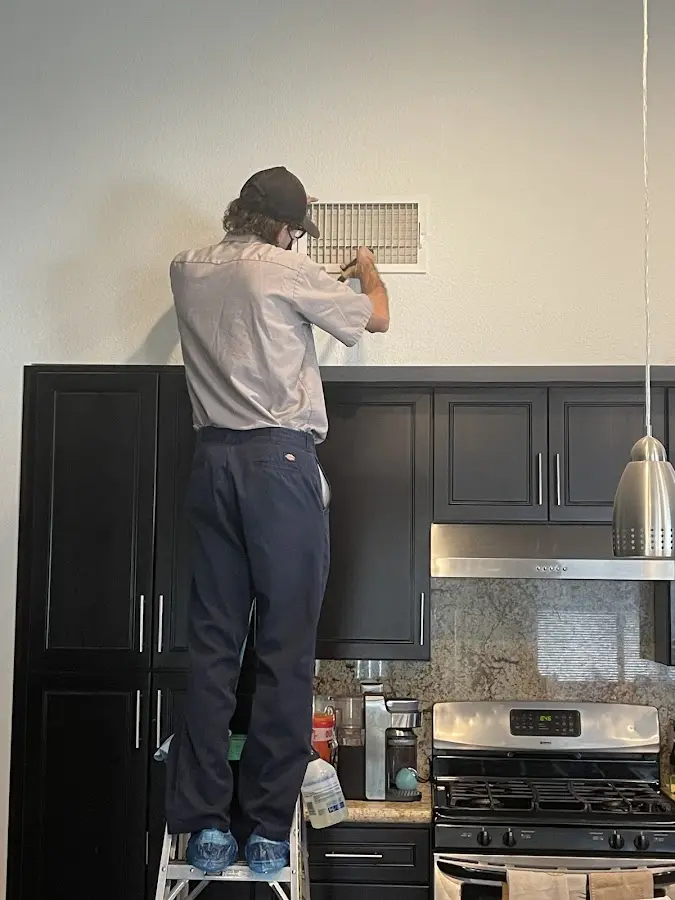 Technician inspecting an air vent during HVAC service in Watertown